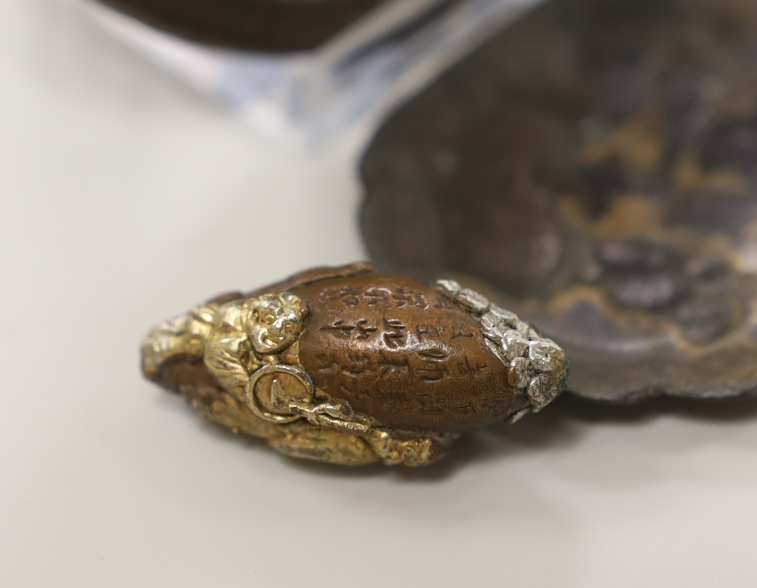 A gilt cast iron Japanese tsuba, gilt bronze ojime and pin dish